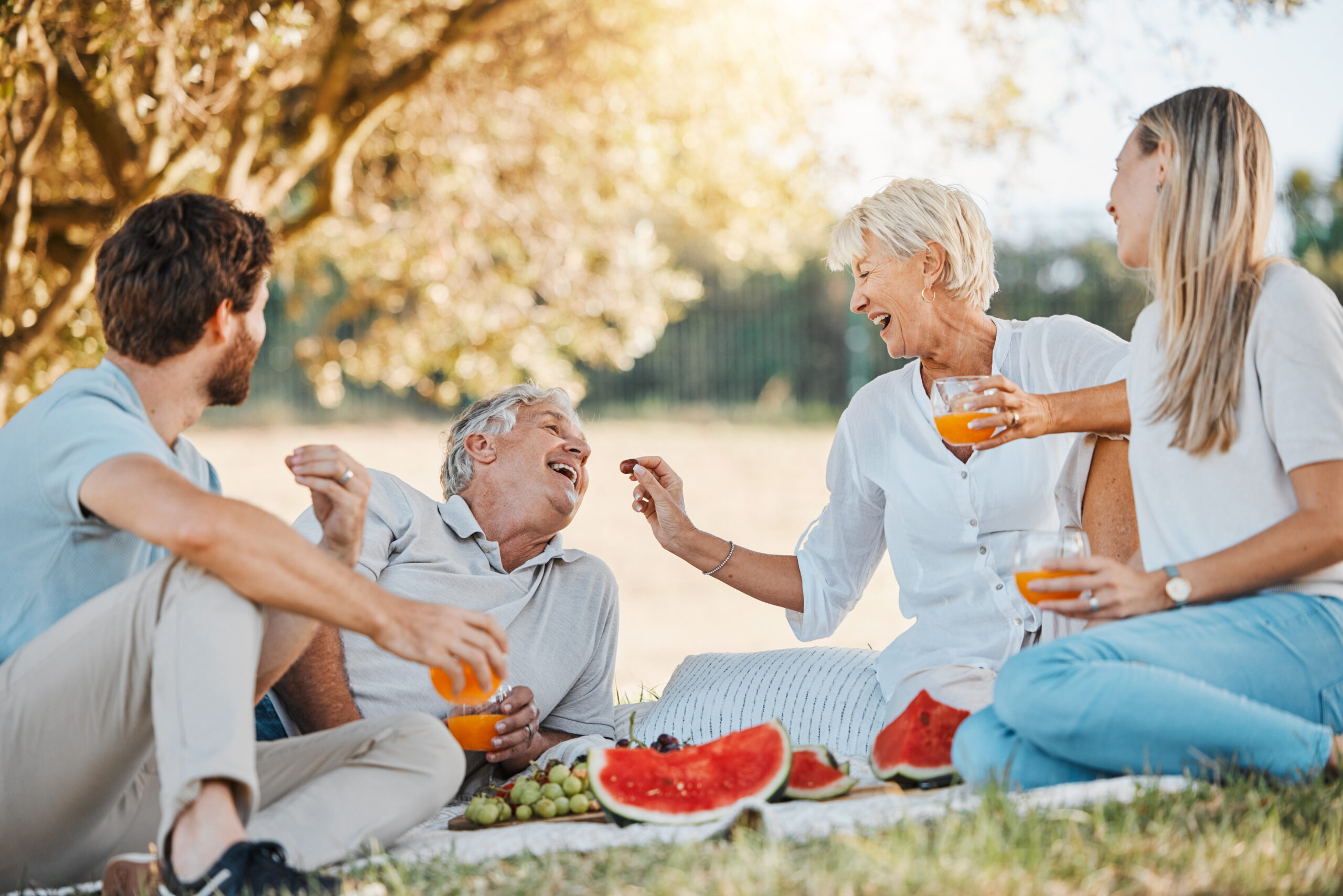 Picnic food, happy family and senior parents, daughter and son having fun, eating grapes and enjoy nature, park or wellness. Fruit, love and relax mature mother, father or garden people bond together.